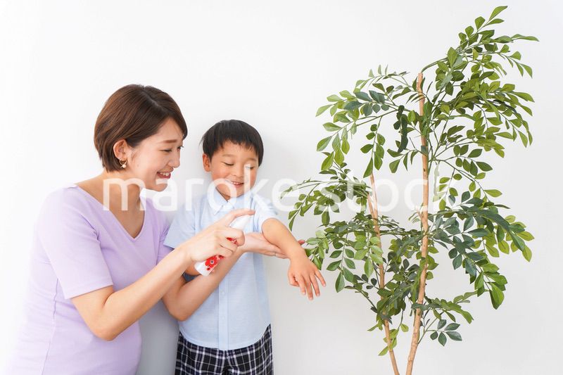 子どもにスプレーをするお母さん