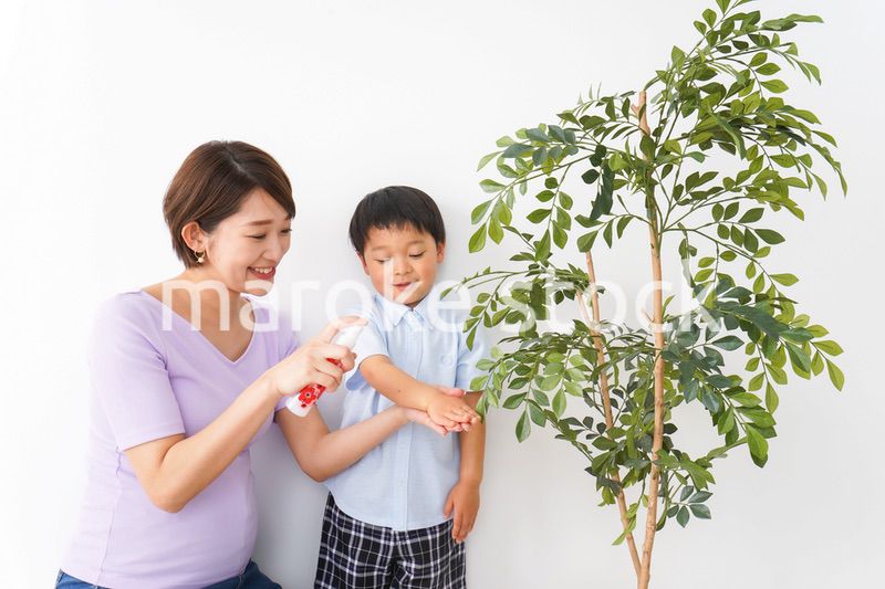 子どもにスプレーをするお母さん