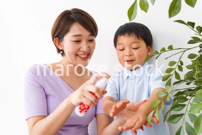子どもにスプレーをするお母さん