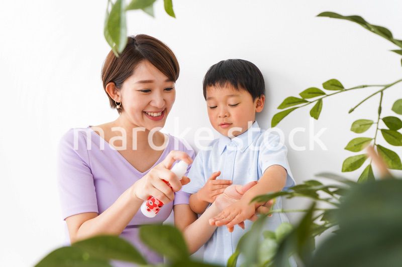 子どもにスプレーをするお母さん
