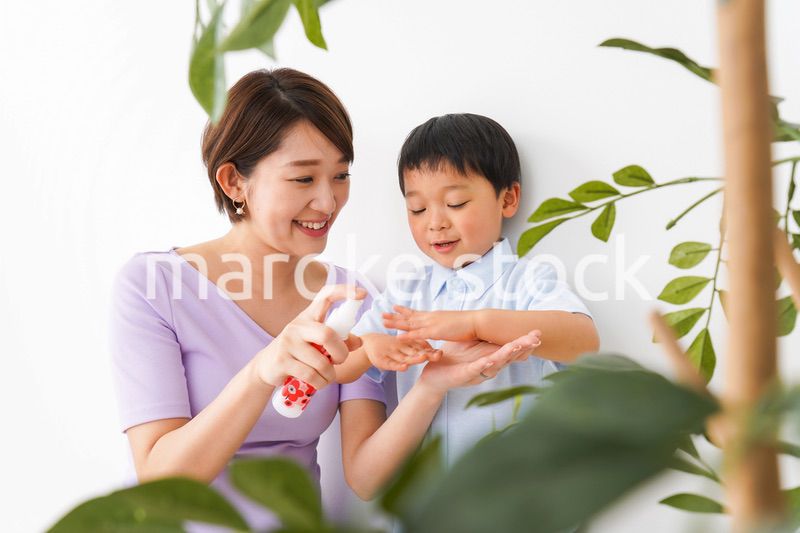 子どもにスプレーをするお母さん