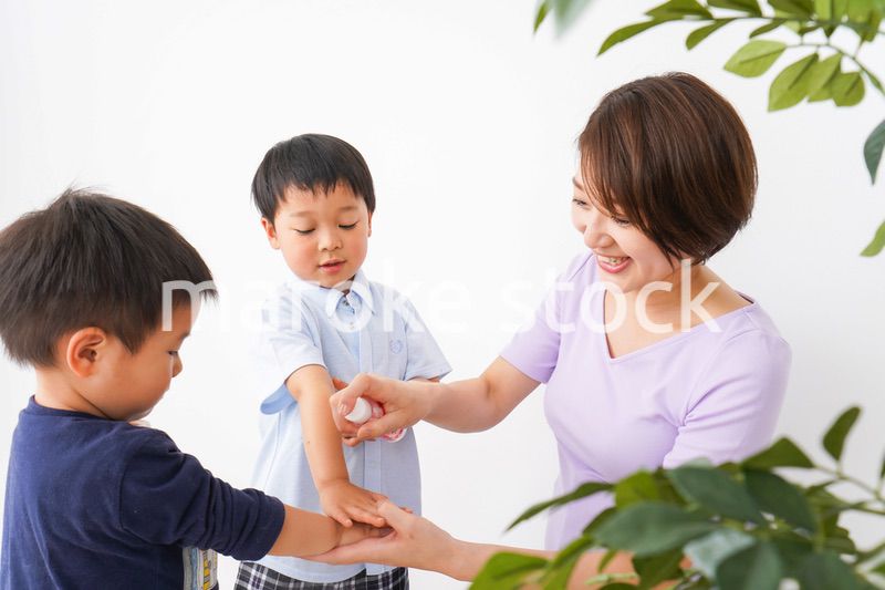 除菌スプレーを子どもにかけるお母さん