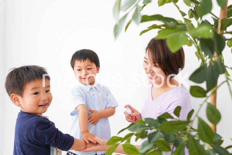 除菌スプレーを子どもにかけるお母さん