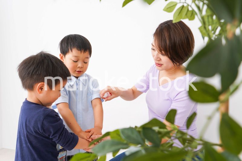 除菌スプレーを子どもにかけるお母さん