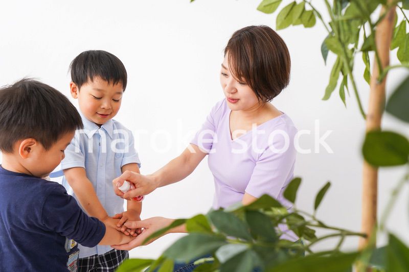 除菌スプレーを子どもにかけるお母さん