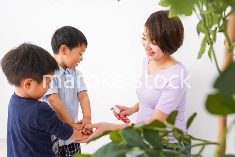 除菌スプレーを子どもにかけるお母さん