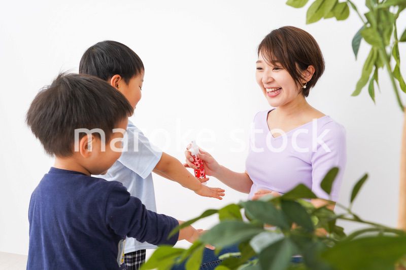 除菌スプレーを子どもにかけるお母さん