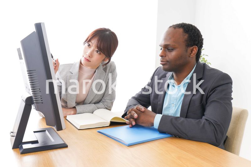 オフィスでパソコンを使う2人のビジネスパーソン