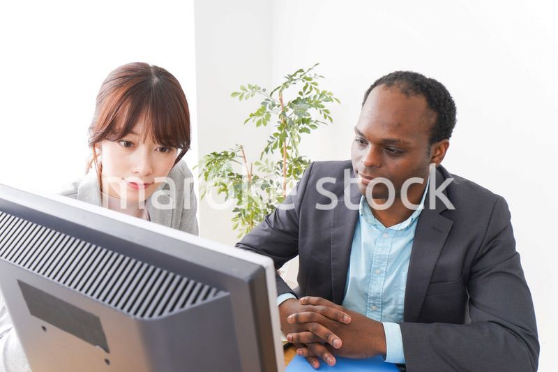 オフィスでパソコンを使う2人のビジネスパーソン