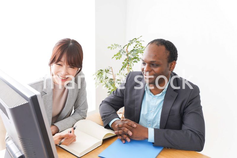 オフィスでパソコンを使う2人のビジネスパーソン