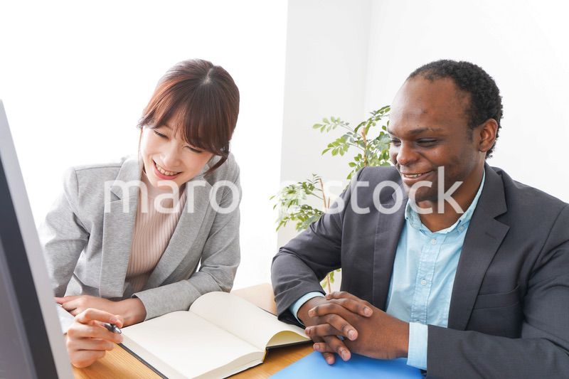 オフィスでパソコンを使う2人のビジネスパーソン