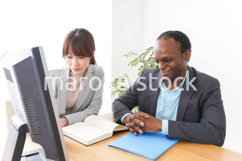 オフィスでパソコンを使う2人のビジネスパーソン
