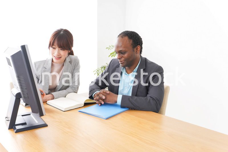 オフィスでパソコンを使う2人のビジネスパーソン