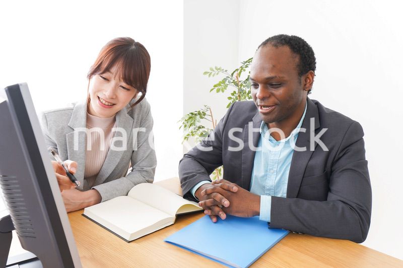 オフィスでパソコンを使う2人のビジネスパーソン