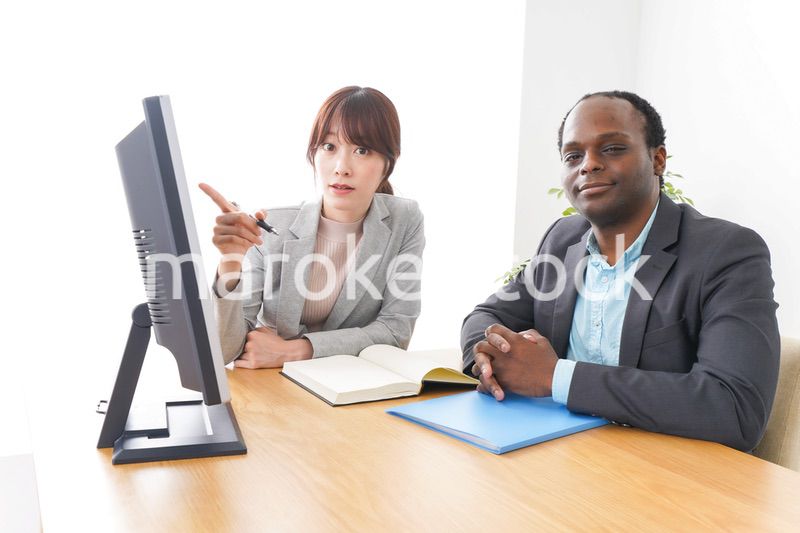 オフィスでパソコンを使う2人のビジネスパーソン
