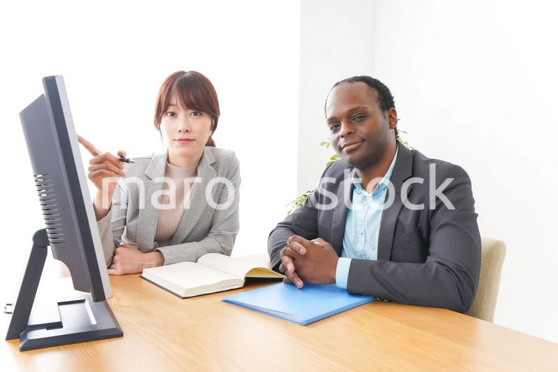 オフィスでパソコンを使う2人のビジネスパーソン