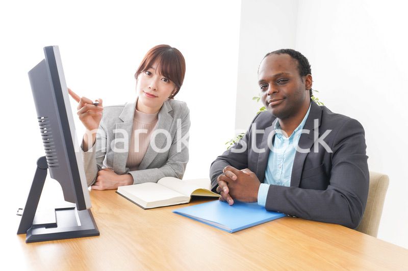 オフィスでパソコンを使う2人のビジネスパーソン