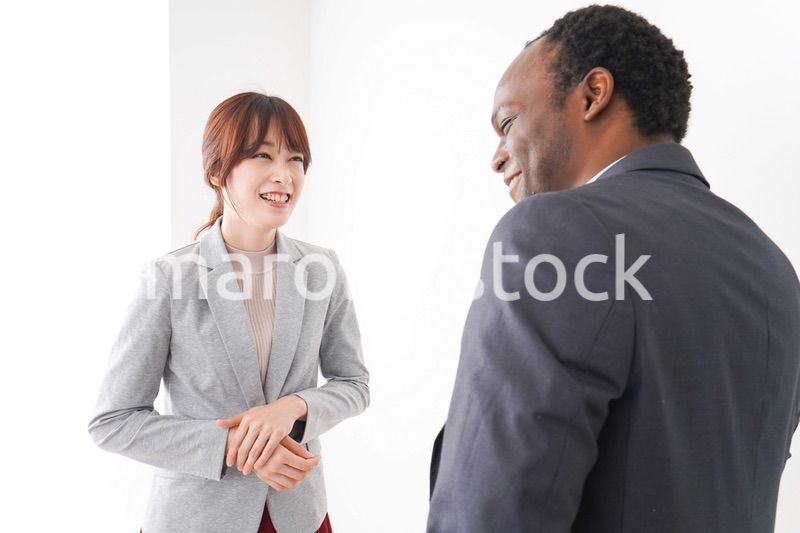 オフィスで意見交換をする2人のビジネスパーソン