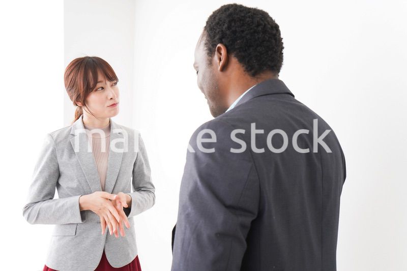 オフィスで意見交換をする2人のビジネスパーソン