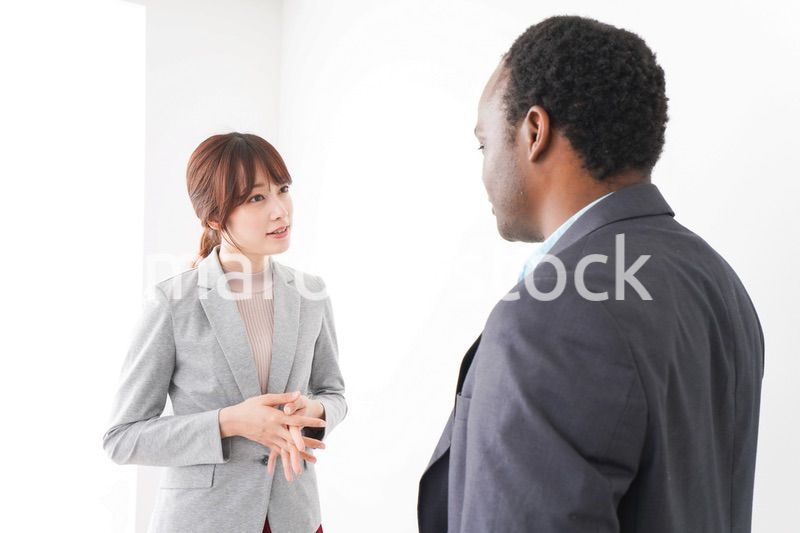 オフィスで意見交換をする2人のビジネスパーソン