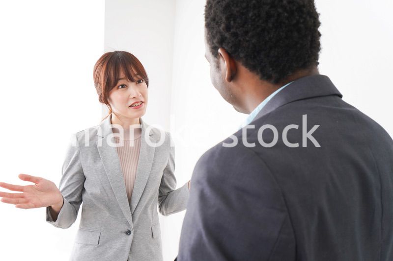 オフィスで意見交換をする2人のビジネスパーソン