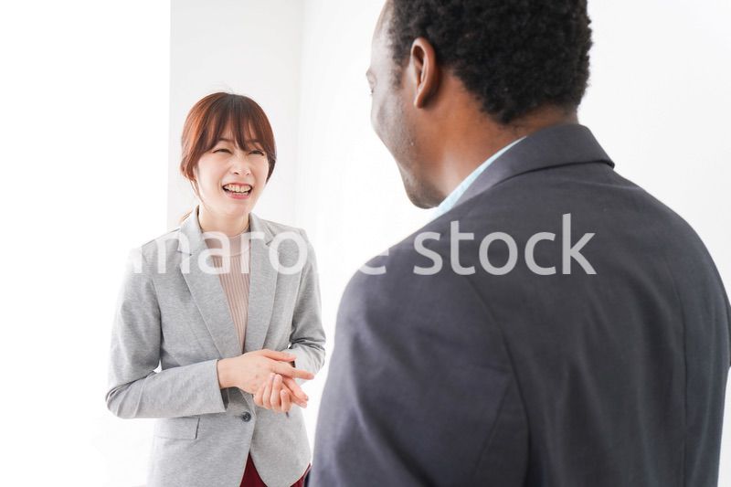 オフィスで意見交換をする2人のビジネスパーソン