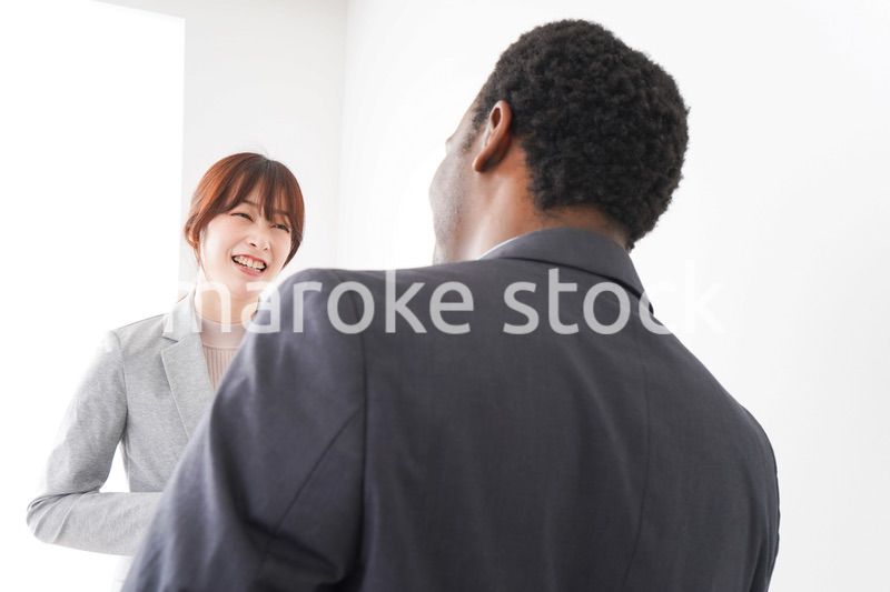 オフィスで意見交換をする2人のビジネスパーソン