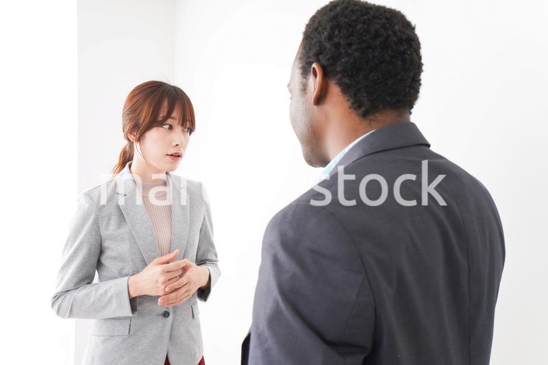 オフィスで意見交換をする2人のビジネスパーソン