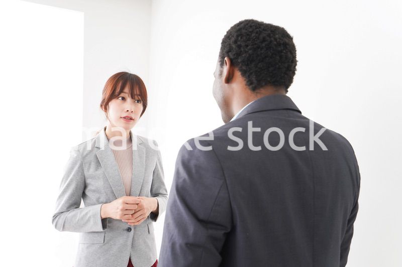 オフィスで意見交換をする2人のビジネスパーソン