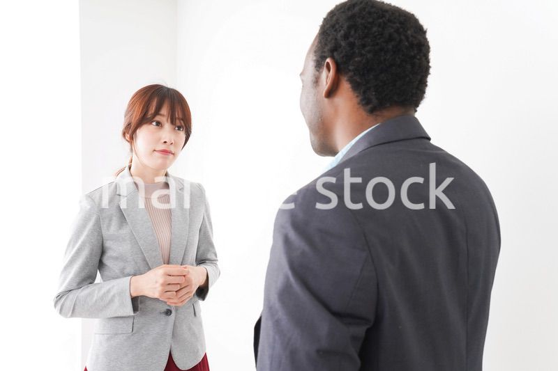 オフィスで意見交換をする2人のビジネスパーソン