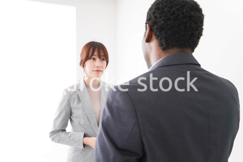 オフィスで意見交換をする2人のビジネスパーソン