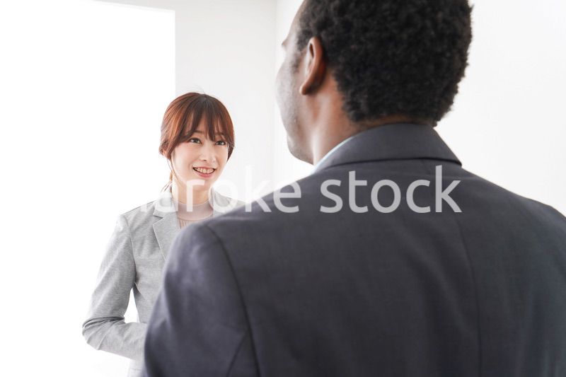 オフィスで意見交換をする2人のビジネスパーソン