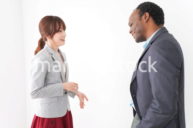 オフィスで意見交換をする2人のビジネスパーソン