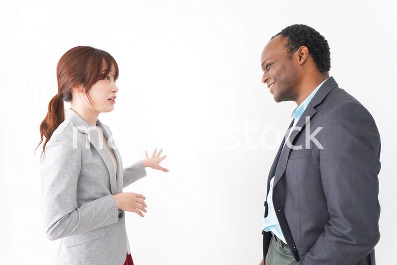 オフィスで意見交換をする2人のビジネスパーソン