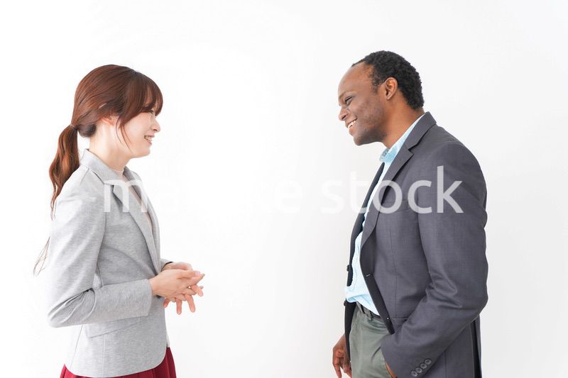 オフィスで意見交換をする2人のビジネスパーソン