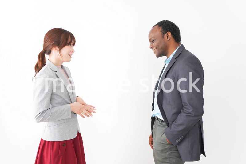 オフィスで意見交換をする2人のビジネスパーソン