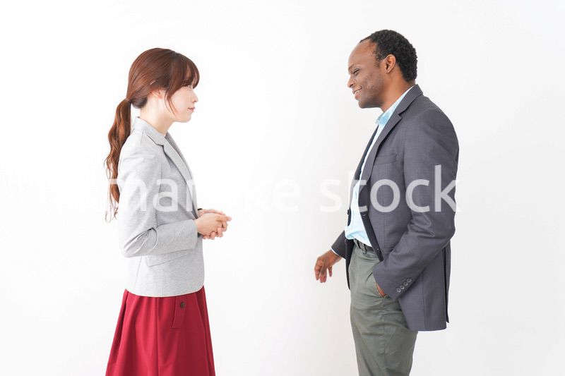 オフィスで意見交換をする2人のビジネスパーソン