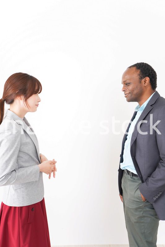 オフィスで意見交換をする2人のビジネスパーソン