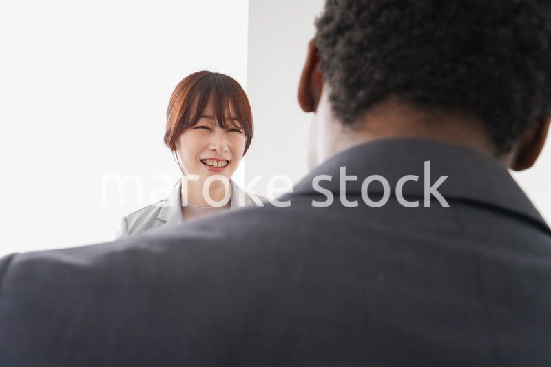 オフィスで意見交換をする2人のビジネスパーソン