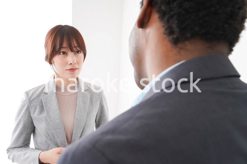 オフィスで意見交換をする2人のビジネスパーソン