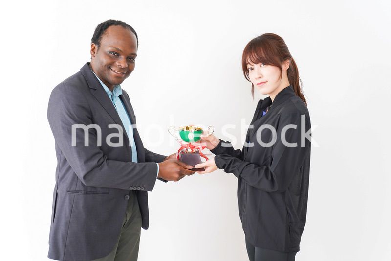 優勝トロフィーを受け取る人