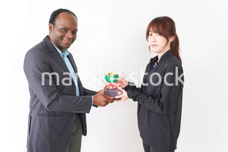 優勝トロフィーを受け取る人