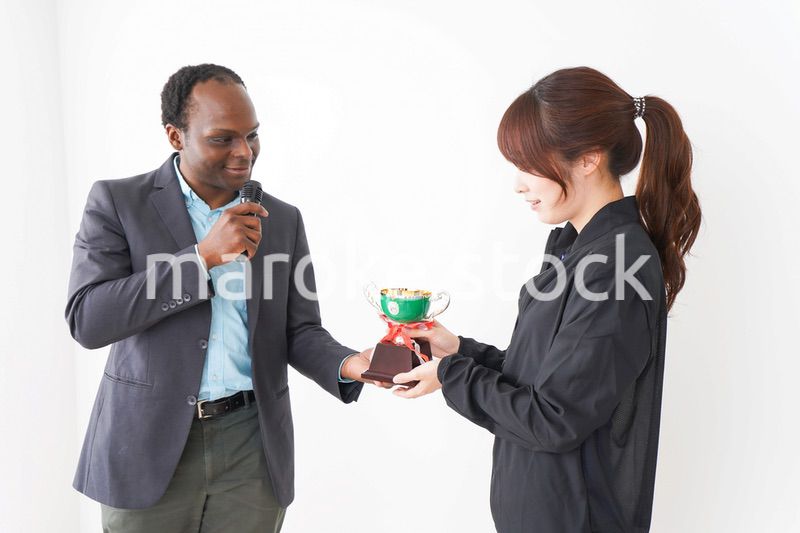 優勝トロフィーを受け取る人