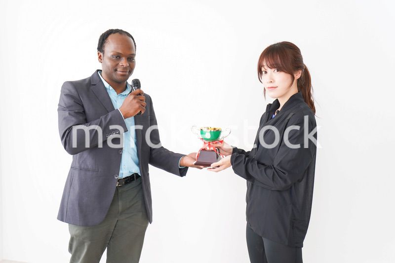 優勝トロフィーを受け取る人