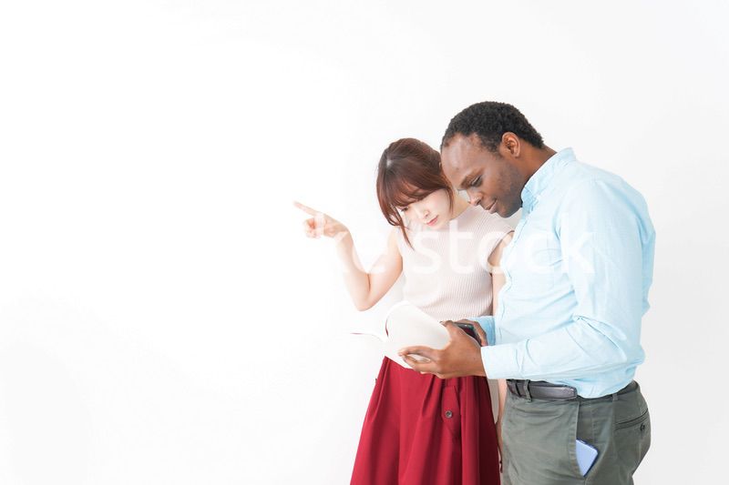 外国人観光客の道案内をする若い女性