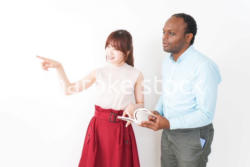 外国人観光客の道案内をする若い女性