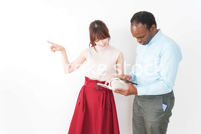 外国人観光客の道案内をする若い女性