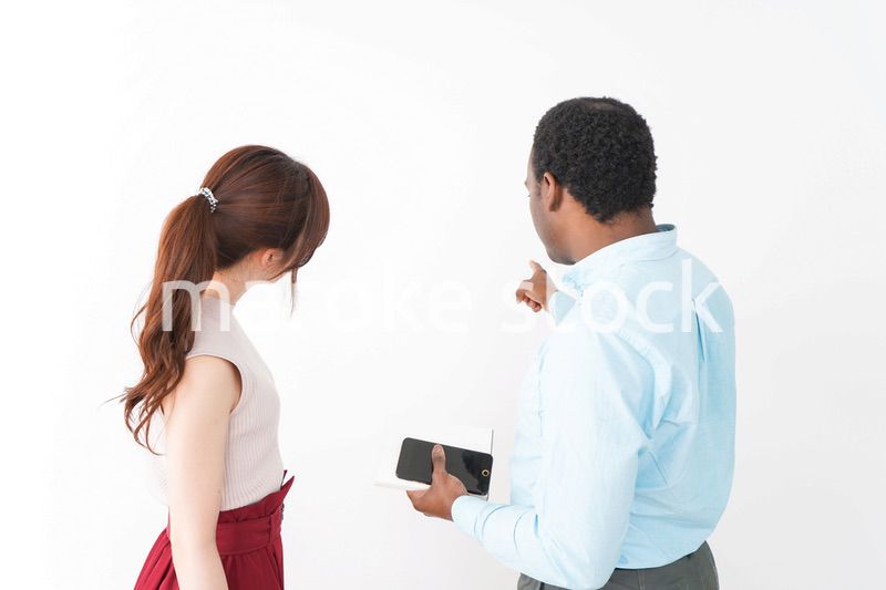 外国人観光客の道案内をする若い女性