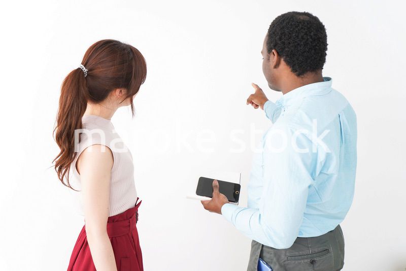 外国人観光客の道案内をする若い女性