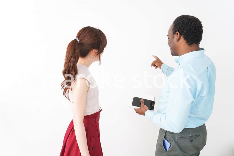 外国人観光客の道案内をする若い女性